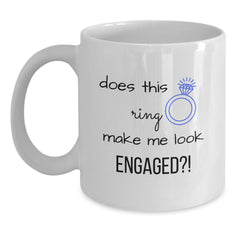White coffee mug with “does this ring make me look ENGAGED?!”