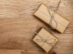 Two brown gift packages with bows tied around them.