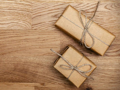 Two brown gift packages with bows tied around them. 